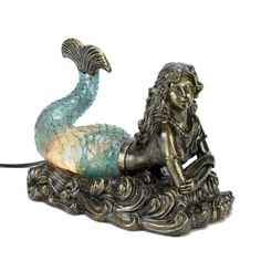 a mermaid lamp sitting on top of a table