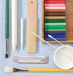 an assortment of crafting supplies including paint, pencils and markers