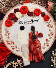 an embroidery project with red and white flowers in the shape of a bride and groom