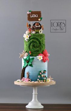 a three tiered cake decorated with grass and flowers