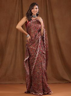 a woman in a red and blue sari posing for the camera with her hands on her hips