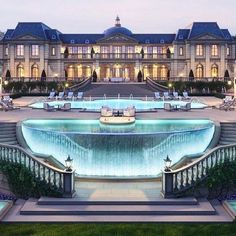 a large mansion with a fountain in front of it