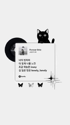 a black cat sitting on top of a white piece of paper next to a record