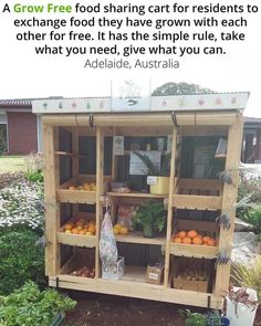 an outdoor fruit stand with oranges and other fruits on it's shelves in front of a house