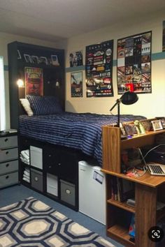 a dorm room with a bed, desk and computer on top of the dressers