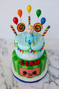 a birthday cake decorated with candy and lollipops for a baby's first birthday