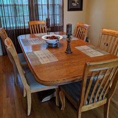 a bowl of food on top of a wooden table in front of a window with blinds