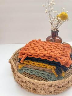 a wicker basket with woven blankets and flowers in it on a white table top