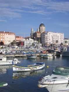 many boats are docked in the water near some buildings and other small structures with domes on them