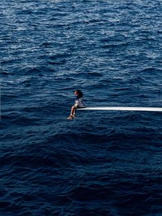 a person sitting on top of a boat in the ocean