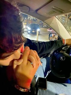 a woman sitting in the driver's seat of a car talking on her cell phone