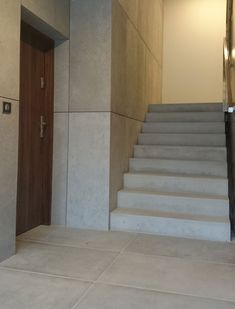 there is a set of stairs leading up to the door in this building with concrete walls