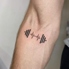 a man's arm with a heartbeat tattoo on it