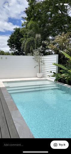 an empty swimming pool surrounded by greenery