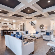 a living room filled with white furniture and lots of pillows on top of it's couches