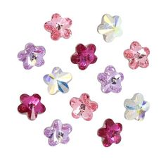 many different colored flowers are arranged in the shape of heart shaped stones on a white background