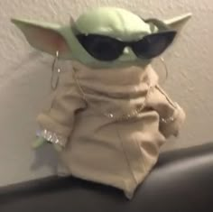 the baby yoda doll is wearing sunglasses