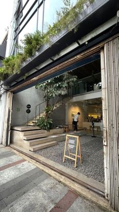 an entrance to a building with stairs and plants on the outside, in front of it