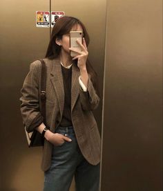 a woman taking a selfie in an elevator with her cell phone up to her ear