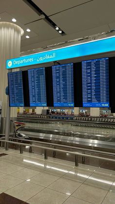 an airport terminal with several large screens displaying the departure times for all passengers to board