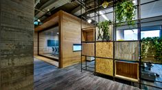 an office with wood paneling and plants growing on the walls, along with glass partitions