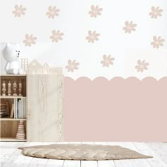 a pink and white room with flowers on the wall