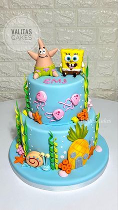 a blue cake decorated with spongebob and other cartoon characters