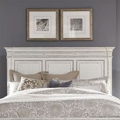 a white bed with two framed pictures above it