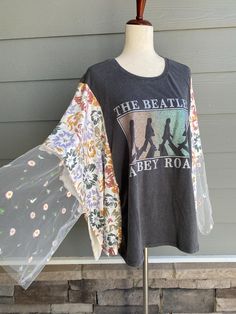 an umbrella and t - shirt sitting on a stand in front of a house with the words the beatin'aby road printed on it