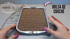 two hands are holding a purse made out of crocheted material and metal frame