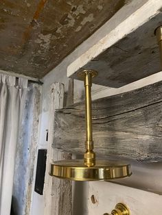 an old light fixture hanging from the ceiling in a room with peeling paint on the walls