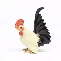 a black and white rooster figurine on a white background