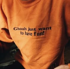 someone wearing an orange shirt that says ghouls just want to have fun