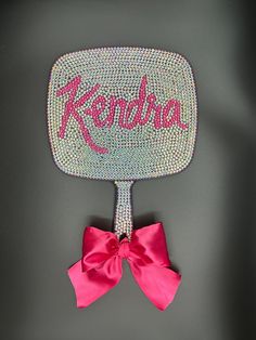 a pink bow sits on top of a mirror with the word kendo written on it