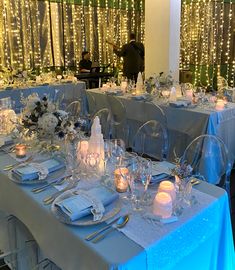 the table is set with silverware, candles and glassware for an elegant dinner