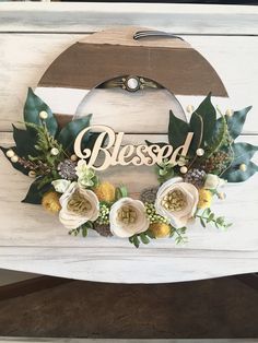 a wooden sign with flowers and leaves on it that says, besod in the center