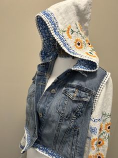 a denim jacket with sunflowers on it and a hoodie over the shoulders