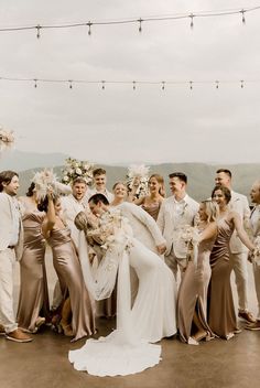 a large group of people standing next to each other in front of a string light