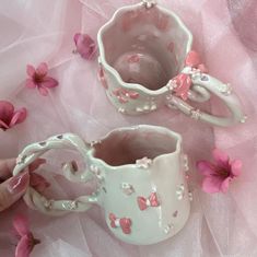 two white vases with pink flowers on a bed of pink tulle and netting