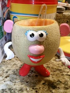 a close up of a cup on a counter top with an odd face and tongue