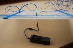 an electronic device is plugged into the side of a table with wires on it