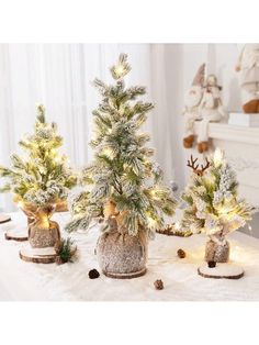 three small christmas trees are sitting on a table