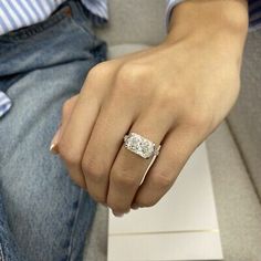 a person sitting on a couch wearing a ring with a diamond in it's center