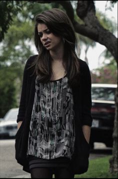 a woman walking down the street with her hand in her pocket and wearing tights