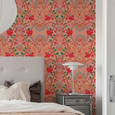 a bed sitting under a mirror next to a wall mounted light on top of a dresser