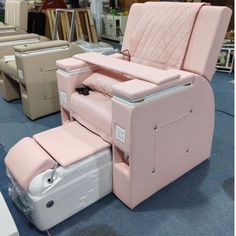 pink reclining chair with foot rest on blue carpeted floor next to other chairs