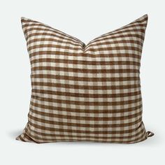 a brown and white checkered pillow on a gray background