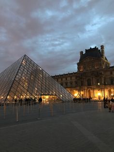 a large glass pyramid sitting in front of a building