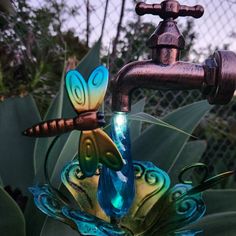 a faucet that is sitting on top of a flower with a dragon figurine attached to it