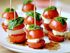 small appetizers with tomatoes and mozzarella are on a white platter